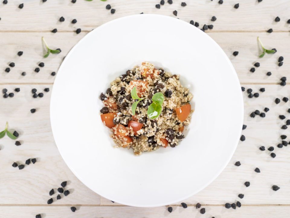Couscous with black chickpeas, aubergines, cherry tomatoes, and cacioricotta cheese