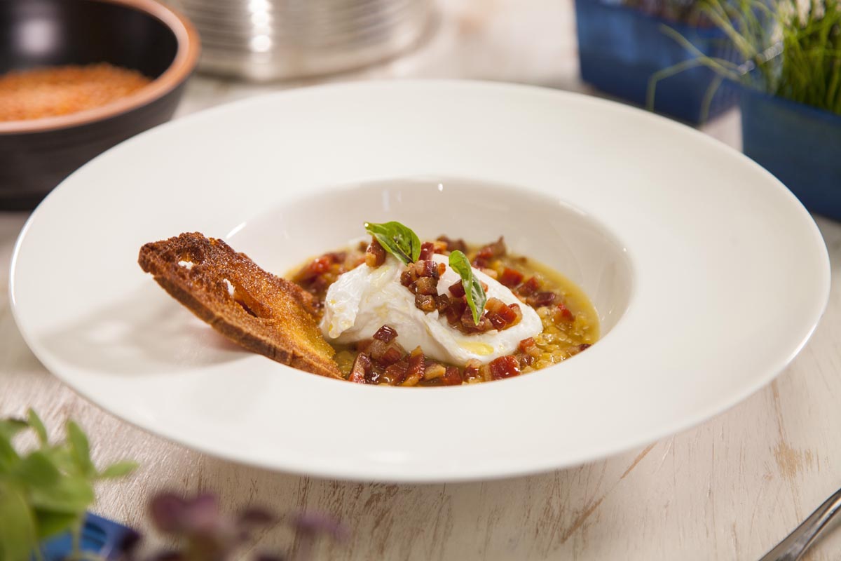 Poached eggs with red-yellow hulled Lentils and crisp bacon